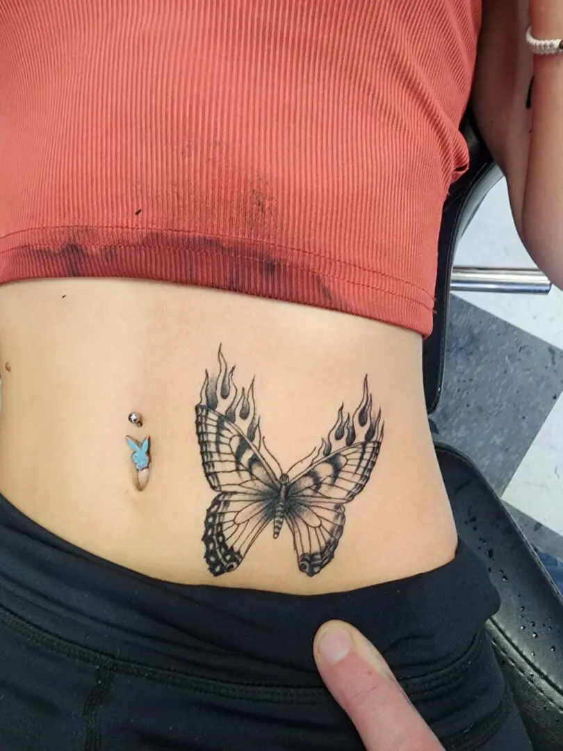 A butterfly on fire as an abdomen tattoo
