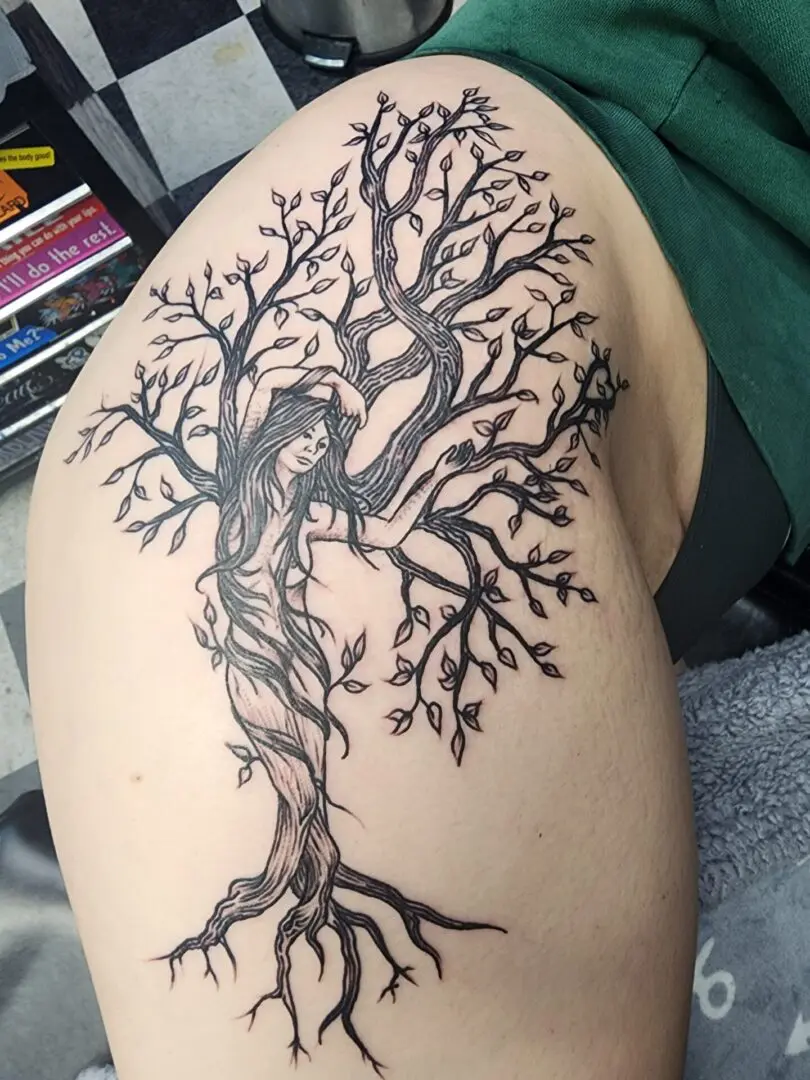 A wild tree with a lady as a leg tattoo