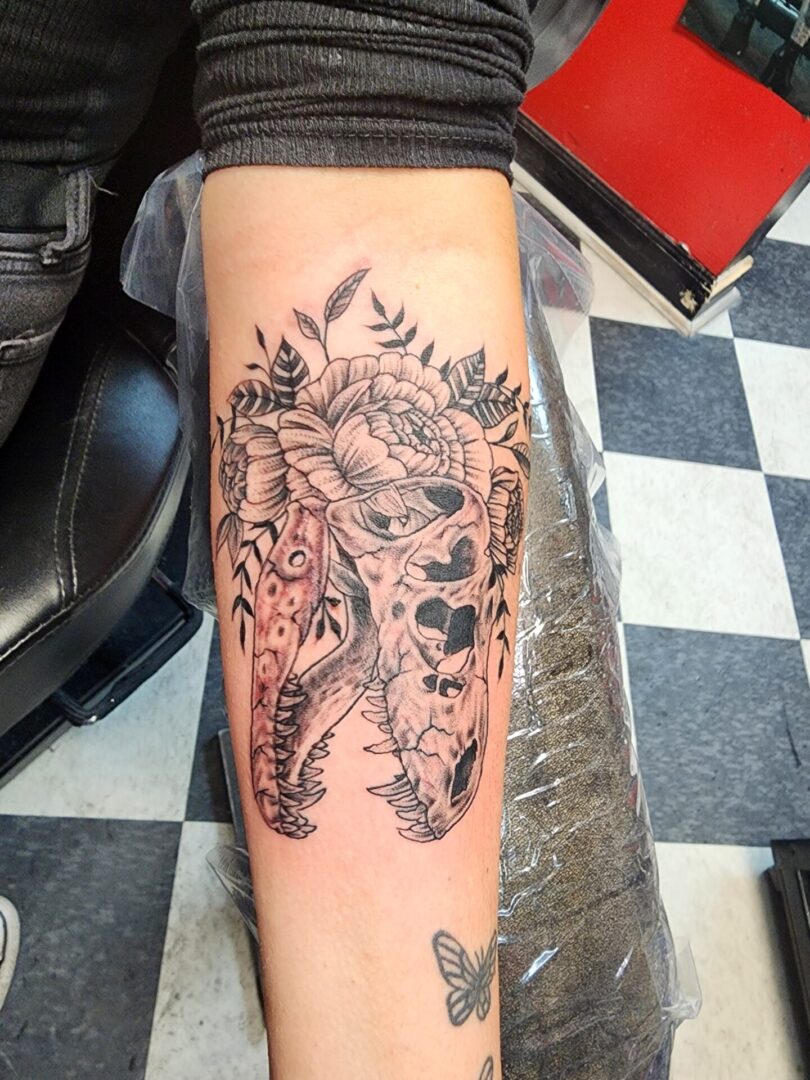 A skull dinosaur as an arm tattoo